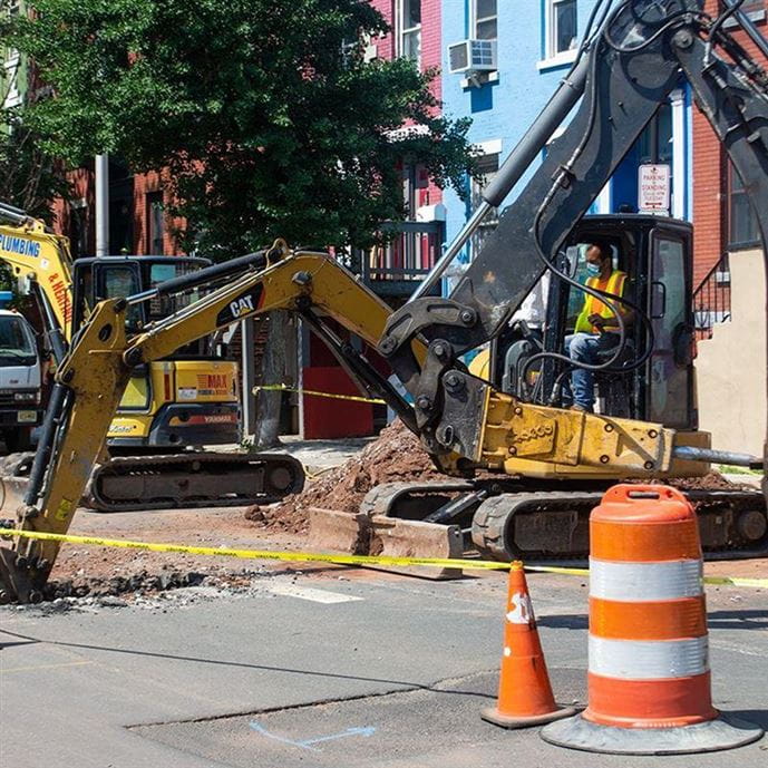 An excavator digs up a street in Newark, NJ as part of the city's lead service line replacement program